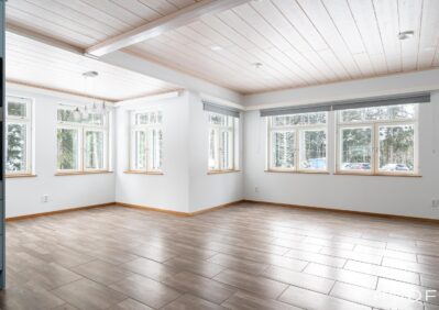 Olohuone ja ruokailutila vasemmalla keittiöstä katsottuna. Runsaasti ikkunoita.