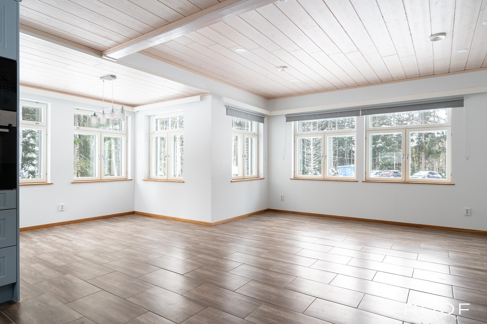 Olohuone ja ruokailutila vasemmalla keittiöstä katsottuna. Runsaasti ikkunoita.